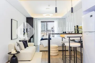 a white living room with a bed and a table at Bloomfields Modern Escape STU In JVC in Dubai