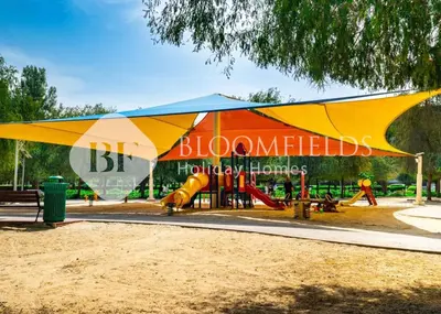 a playground with a large tent in a park at Bloomfields Modern Escape STU In JVC in Dubai