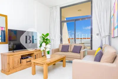 a living room with a tv and a couch at Bloomfields 1Br The Avenue Suite Bingahtti in Dubai