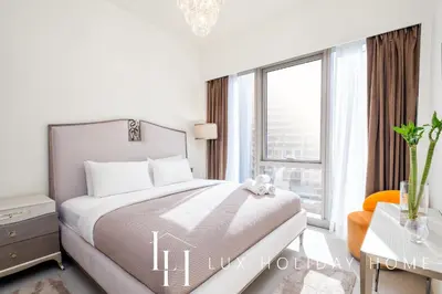 a white bedroom with a bed and a window at LUX The Grande Signature Skyline Suite 2 in Dubai