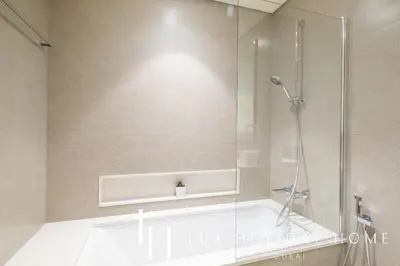 a bathroom with a shower and a bath tub at LUX The Grande Signature Skyline Suite 2 in Dubai