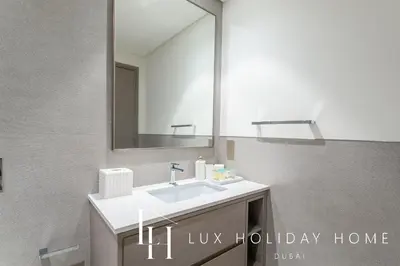 a bathroom with a sink and a mirror at LUX The Grande Signature Skyline Suite 2 in Dubai