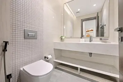 a bathroom with a toilet and a sink and a mirror at Stunning 1 Bdr Luxury with Burj Khalifa View in Dubai