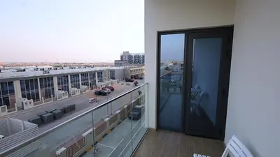 a balcony with a view of a city at 2 Bedroom Elegant Apartment in Dubailand in Dubai