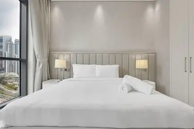 a bedroom with a large white bed with a window at Spacious 3BR , Balcony & City Views by Bhavan Vacation Homes in Dubai