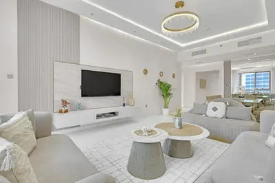 a white living room with a couch and a tv at Spacious 3BR , Balcony & City Views by Bhavan Vacation Homes in Dubai