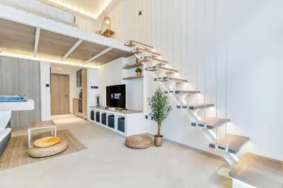 a living room with a spiral staircase in a house at Luxury Loft with Balcony in JVC, Oxford Terraces 2 in Dubai