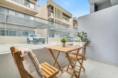 a table and chairs on the balcony of a building at Luxury Loft with Balcony in JVC, Oxford Terraces 2 in Dubai