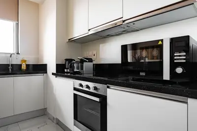 a kitchen with black counter tops and a microwave at Luxury 2Br Apt Stunning Views in Amna Tower by Simply Comfort in Dubai