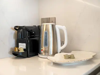 a coffeemaker sitting on top of a counter with a plate at Grande Signature 2 Bedroom Apartments I Persian Gulf Views I Free Parking, Gym, Pool, Wi-Fi & PS5 I by Skyline Serenity in Dubai