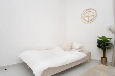 a white bedroom with a bed and a plant at GuestReady - Fabulous home with Marina Canal views in Dubai