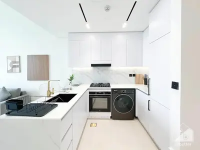 a white kitchen with a stove and a dishwasher at Luxury & Comfort at Binghatti Amber with Balcony in Dubai