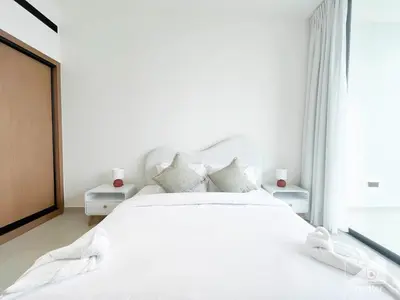 a white bedroom with a white bed and a window at Luxury & Comfort at Binghatti Amber with Balcony in Dubai