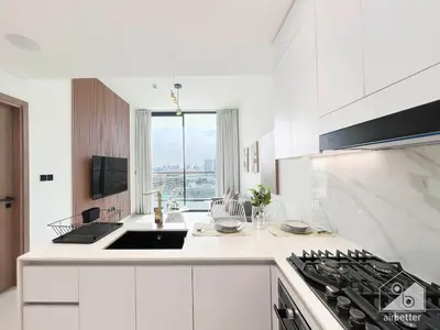 a white kitchen with a sink and a stove at Luxury & Comfort at Binghatti Amber with Balcony in Dubai