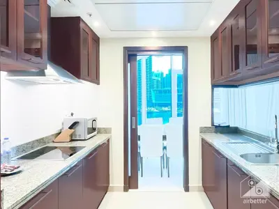 a kitchen with wooden cabinets and a view of the city at Luxury 2B Apt with Full Marina Views - Delphine in Dubai