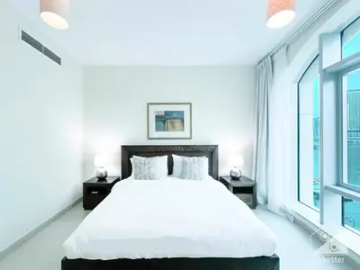 a white bedroom with a large bed and two windows at Luxury 2B Apt with Full Marina Views - Delphine in Dubai