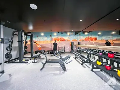 a gym with cardio equipment and a tennis court at Sophisticated 1B Apartment in Belgravia Heights II in Dubai