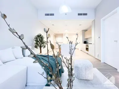 a living room with a white couch and a table at Sophisticated 1B Apartment in Belgravia Heights II in Dubai