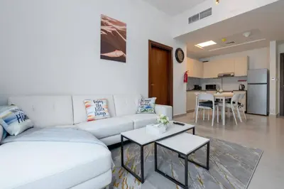 a living room with a white couch and a table at Delightful 2 Bedrooms In Jumeirah Village Circle in Dubai