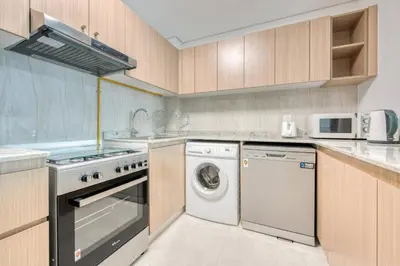 a kitchen with a washing machine and a washer at Serene 2 Bedrooms Apartment in Dubai