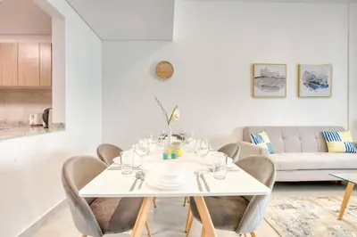 a white dining room with a white table and chairs at Serene 2 Bedrooms Apartment in Dubai