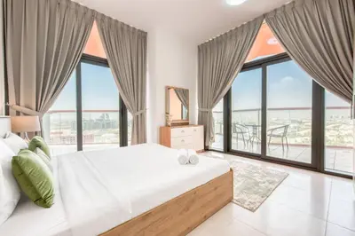 a bedroom with a large bed and large windows at Serene 2 Bedrooms Apartment in Dubai