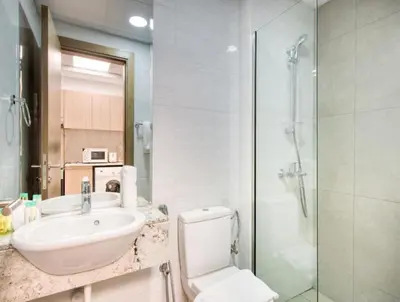 a bathroom with a toilet and a sink and a shower at Posh Studio Apartments in Dubai