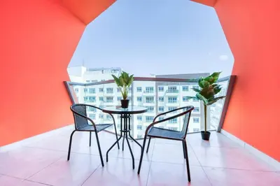 a table and two chairs in a room with a window at Posh Studio Apartments in Dubai