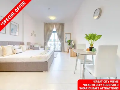 a living room with a bed and a table at Posh Studio Apartments in Dubai
