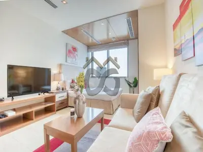 a living room with a couch and a tv at Restful studio Apartment in Dubai Sports City in Dubai