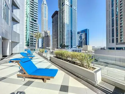 a row of lounge chairs on the roof of a building at Vacationer I Sophisticated 2 Bedroom Apartment I High Floor I Scenic Skyline Escape I Torch Tower - Marina in Dubai