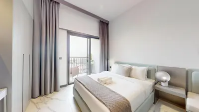a bedroom with a bed and a large window at Mag Eye - Cozy Studio in Meydan in Dubai
