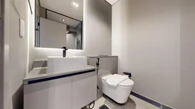 a white bathroom with a toilet and a sink at Mag Eye - Cozy Studio in Meydan in Dubai