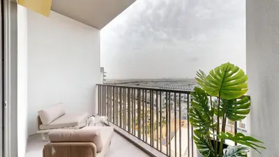 a living room with a balcony with a plant at Mag Eye - Cozy Studio in Meydan in Dubai
