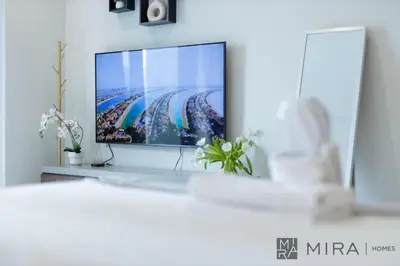 a flat screen tv sitting on a shelf in a living room at Mira Holiday Homes - newly and cosy studio with balcony in Business Bay in Dubai