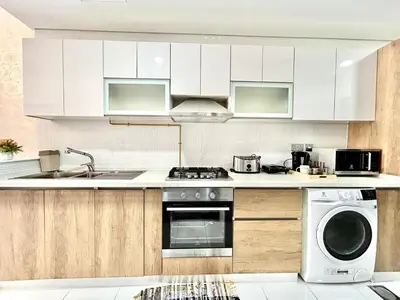 a kitchen with white cabinets and a dishwasher at Homes2Retreat - Resort Living Close to Miracle Garden in Dubai