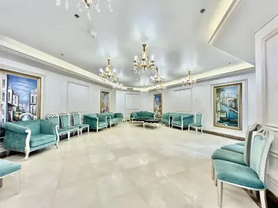 a waiting room with blue chairs and a table and chandeliers at Homes2Retreat - Resort Living Close to Miracle Garden in Dubai