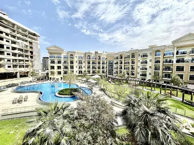 an apartment complex with a swimming pool and palm trees at Homes2Retreat - Resort Living Close to Miracle Garden in Dubai