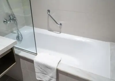 a bathroom with a shower and a bath tub with a towel at Bespoke Holiday Homes - Luxurious Studio in Damac Maison Prive in Dubai