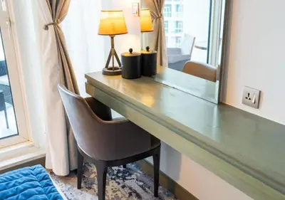 a desk with a lamp and a chair in a room at Bespoke Holiday Homes - Luxurious Studio in Damac Maison Prive in Dubai