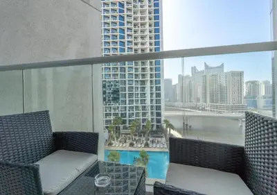 a balcony with chairs and a view of a city at Bespoke Holiday Homes - Luxurious Studio in Damac Maison Prive in Dubai