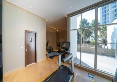 a gym with a treadmill and a large window at Bespoke Holiday Homes - Luxurious Studio in Damac Maison Prive in Dubai