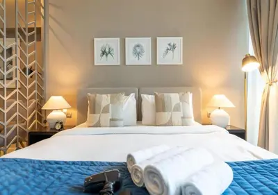 a bedroom with a large bed with towels on it at Bespoke Holiday Homes - Luxurious Studio in Damac Maison Prive in Dubai