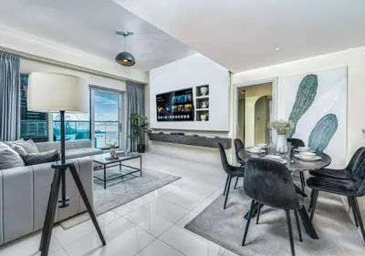 a living room with a table and chairs at Pristine 2BR Apt in Dubai! JBR, Marina & Sea View in Dubai