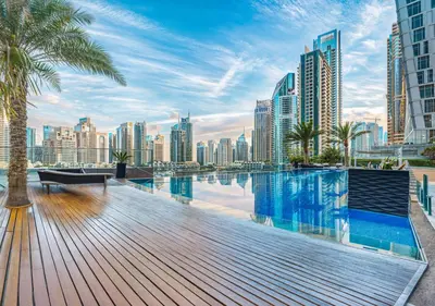 a swimming pool with a city skyline in the background at Pristine 2BR Apt in Dubai! JBR, Marina & Sea View in Dubai