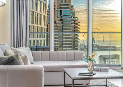 a living room with a couch and a large window at Pristine 2BR Apt in Dubai! JBR, Marina & Sea View in Dubai