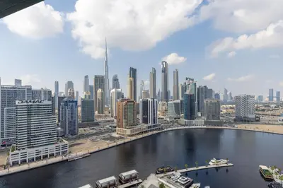 a view of a city with boats in the water at Waves - Elegant Waterfront Living in Dubai's Business Bay in Dubai