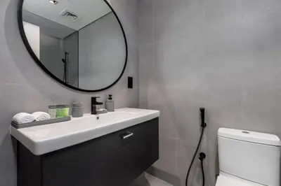 a bathroom with a sink and a mirror and a toilet at Waves - Elegant Waterfront Living in Dubai's Business Bay in Dubai