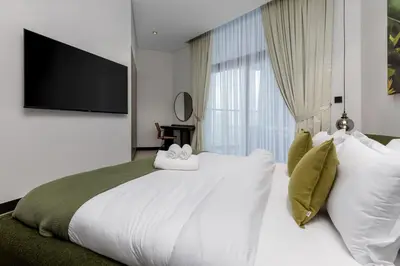a bedroom with a large white bed and a large window at Waves - Elegant Waterfront Living in Dubai's Business Bay in Dubai