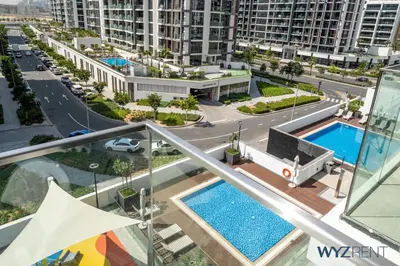 an apartment with two swimming pools and a street at Winter Bliss Studio Azizi Riviera 9 Pool View in Dubai